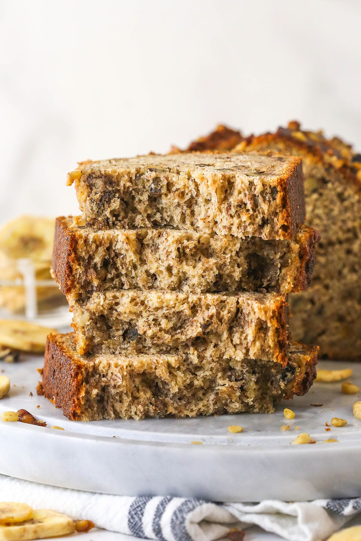 This easy Banana Nut Bread is top-notch. Supremely moist with BIG banana flavor and a hint of cinnamon, it's sure to become your new go-to! A stack of banana nut bread slices.